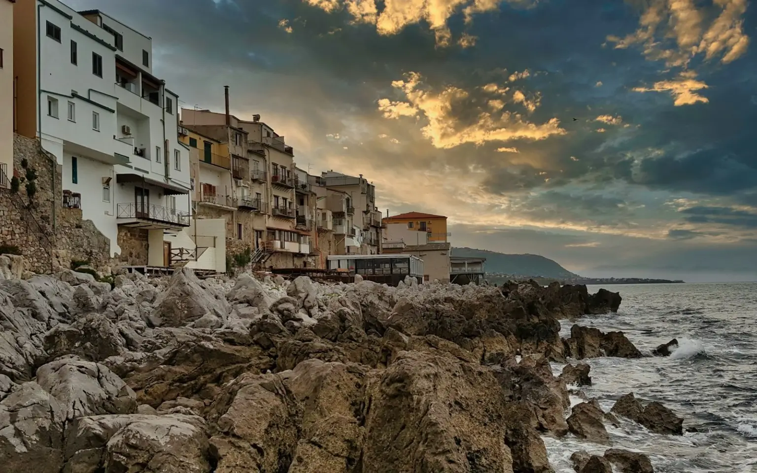 Buildings above a rocky Sicilian shore