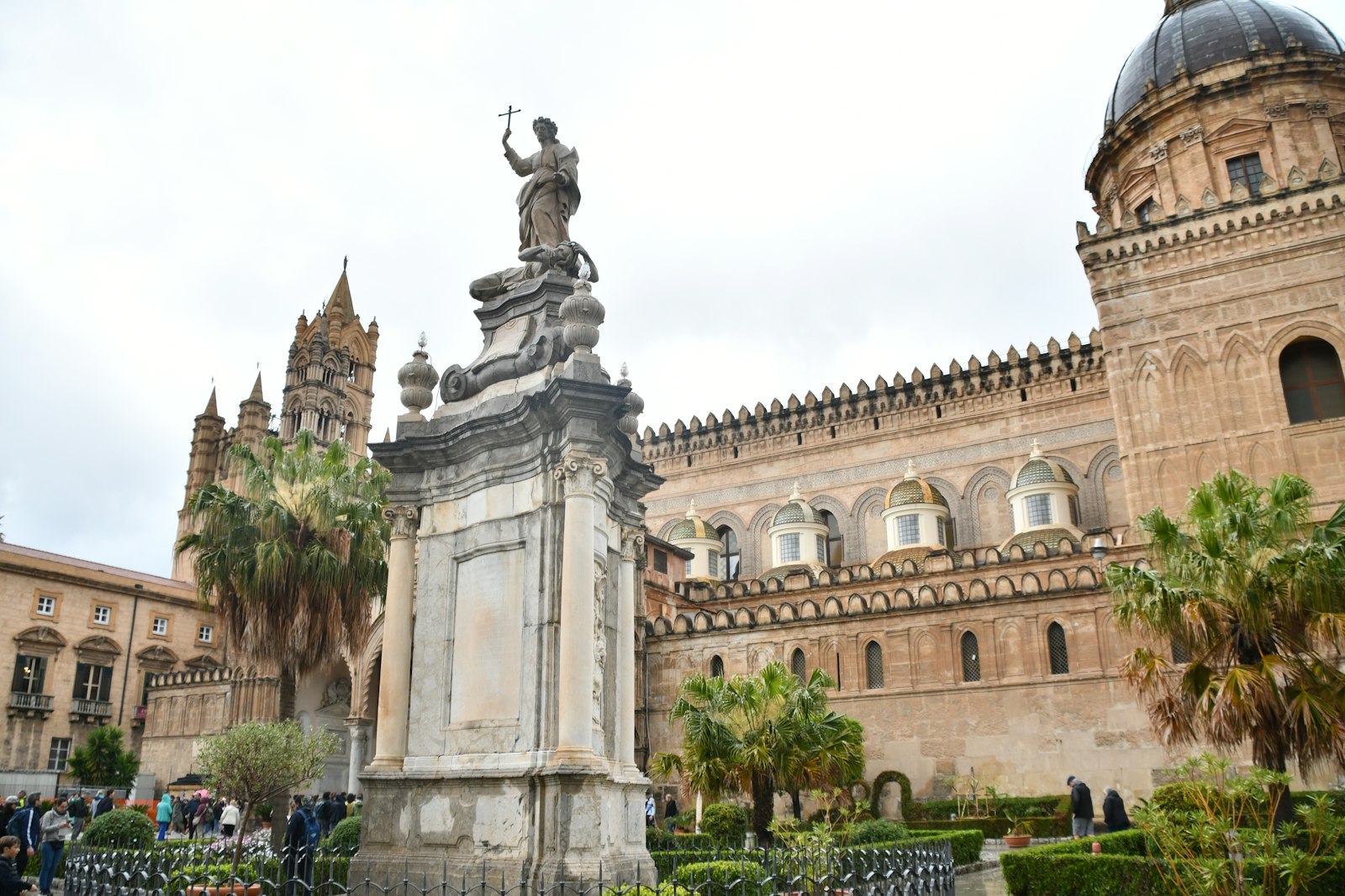 A statue in front of a large historic building in central Palermo
