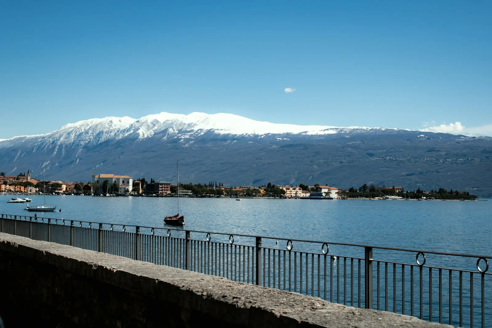 Snow-capped mountains above a lakeside town on Lake Garda